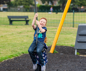 Child swinging on play equipment